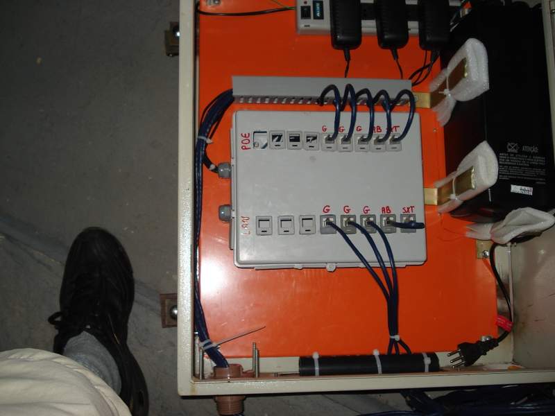Dentro da caixa, conectores POE e LAN e o no-break no canto.