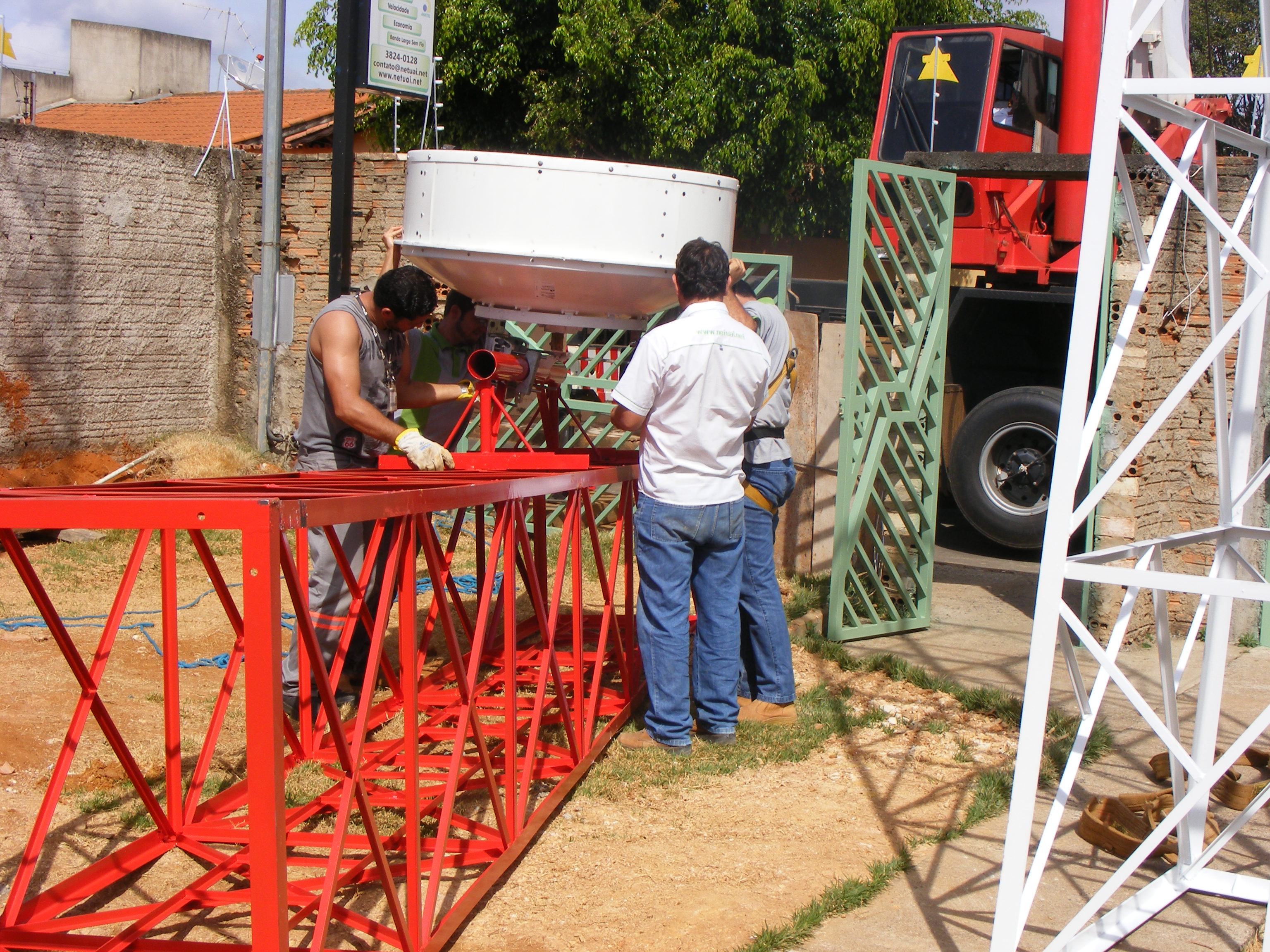 Todos ajudando a firmar a antena no suporte, e fixando a mesma. Vamos la gente, apertar parafusos;